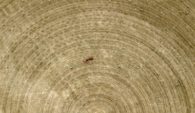 A tractor drives through a field in drought